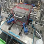 silicone mold sitting on the bottom plate of a silicone compression molding machine