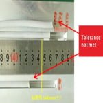 Calipers measuring a silicone extrusion strip, reading outside the 1445±7 mm tolerance