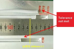 Calipers measuring a silicone extrusion strip, reading outside the 1445±7 mm tolerance