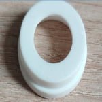 White silicone grommet ring with a flange, the rejected part from this complaint